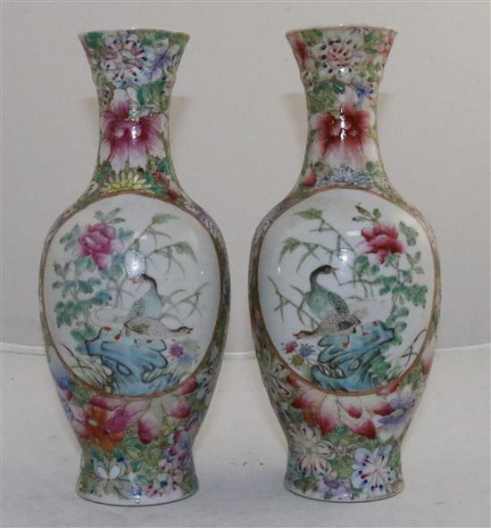 A pair of Chinese famille rose millefleur bottle vases, early 20th century, 24.5cm